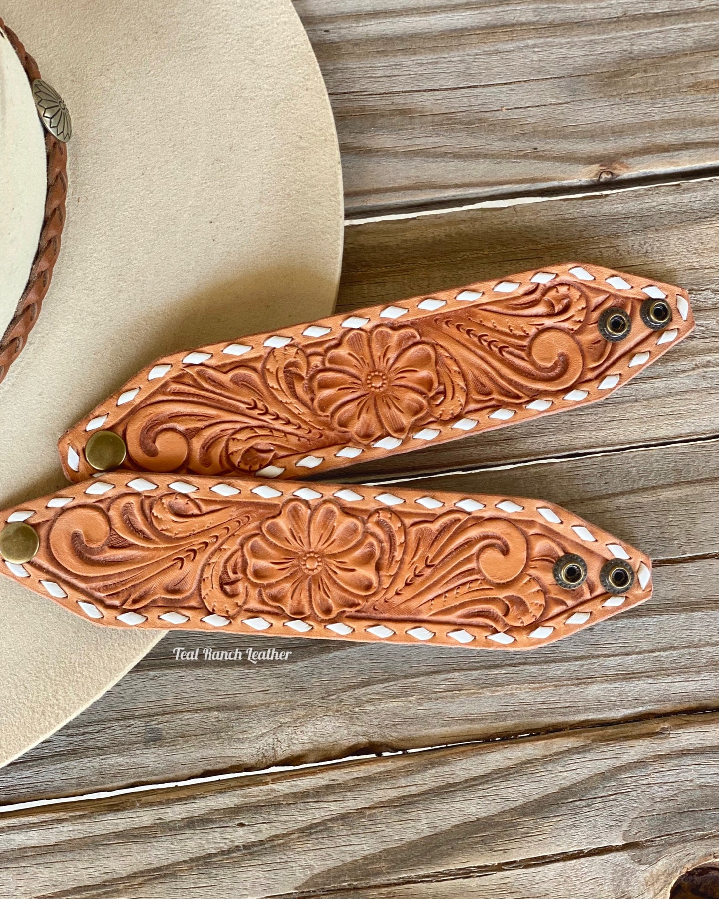 Tooled leather cuff with white buckstitch