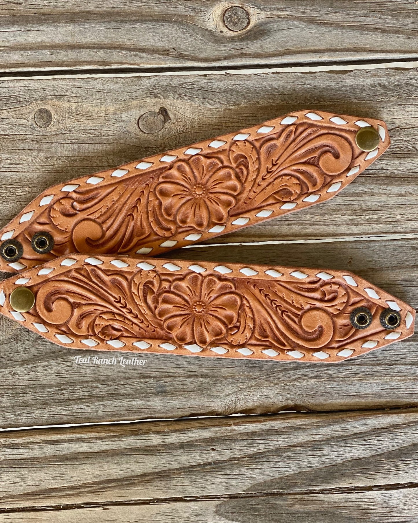 Tooled leather cuff with white buckstitch