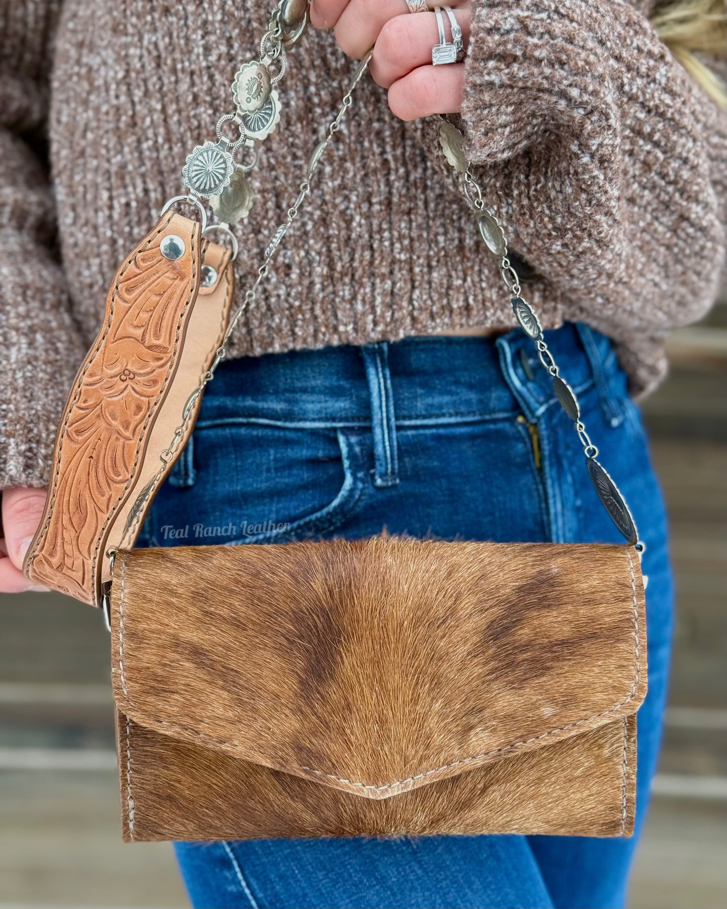 Small hair on hide cross body purse with tooled leather strap and concho chain