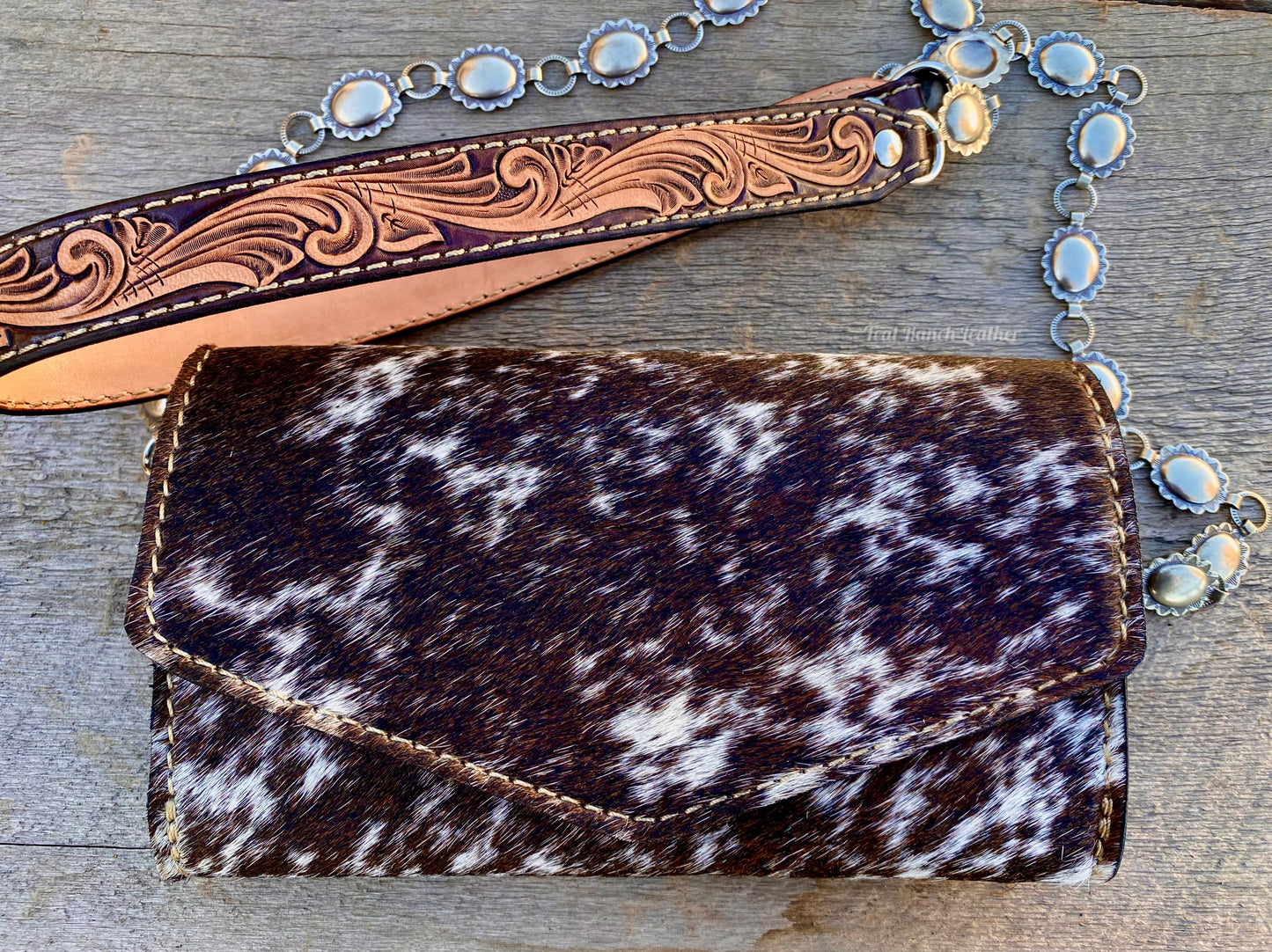 Small hair on hide cross body purse with tooled leather and concho chain