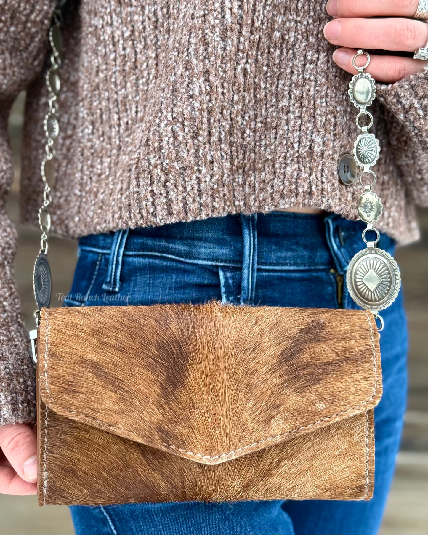 Small hair on hide cross body purse with tooled leather strap and concho chain