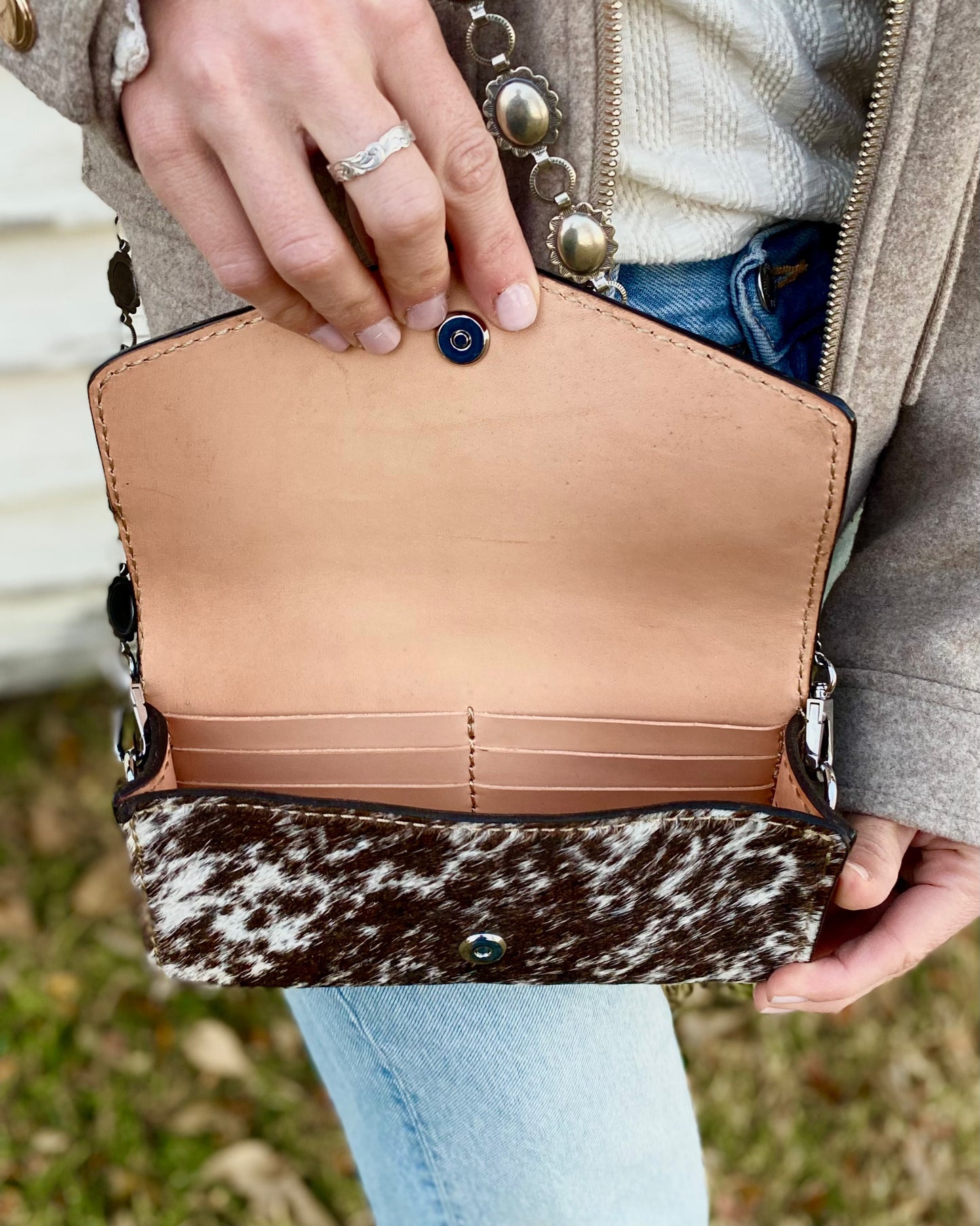 Small hair on hide cross body purse with tooled leather and concho chain